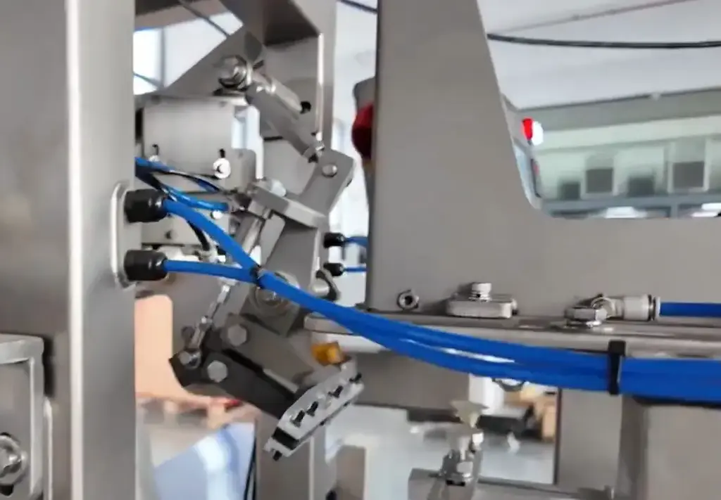 A-mechanical-arm-with-a-set-of-suction-cups-picks-the-front-pouch-from-the-magazine