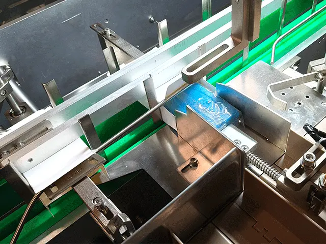 product-is-pushed-into-the-open-end-of-the-carton-by-a-mechanical-pusher-bar